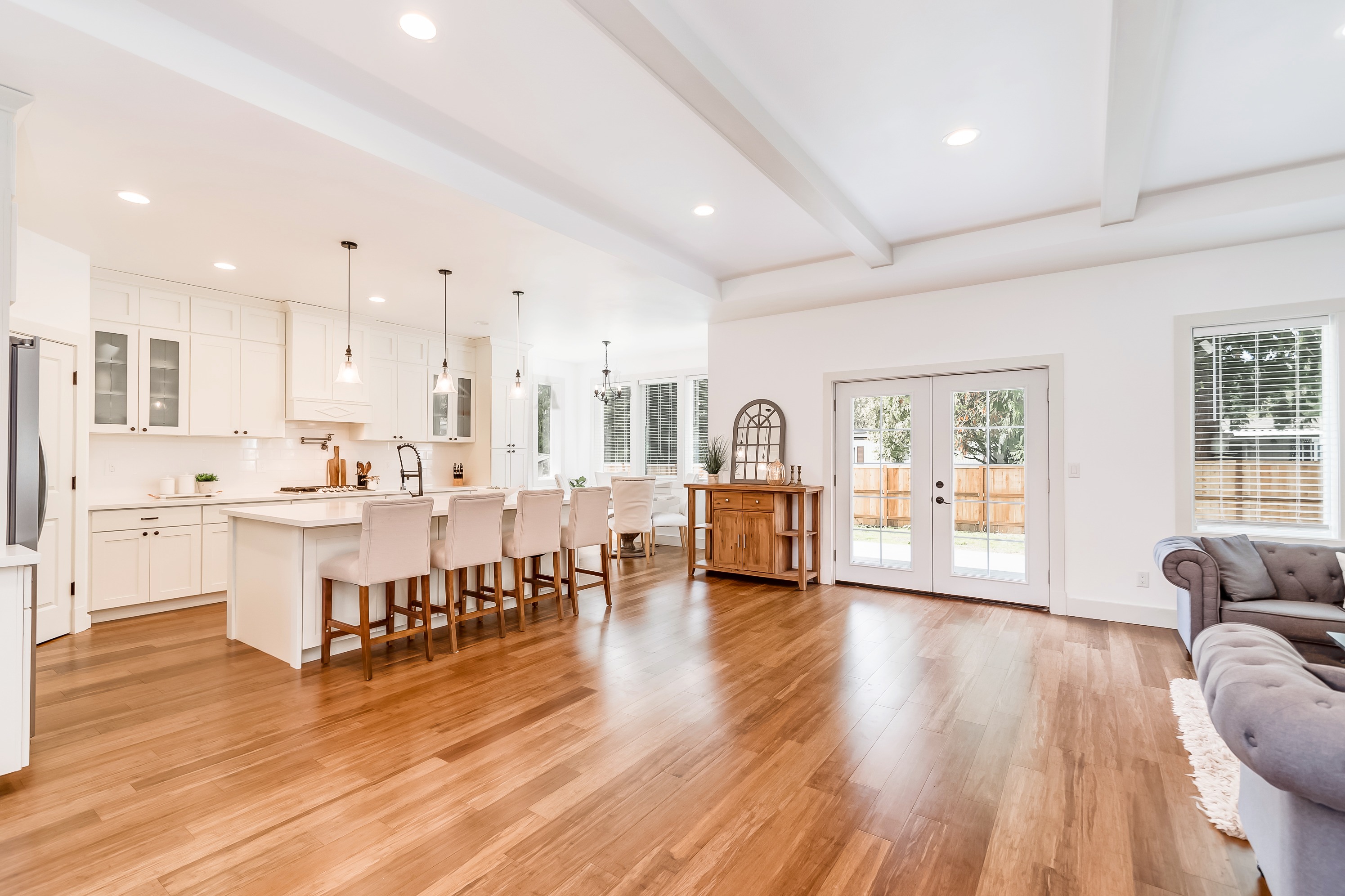 A bright open-concept great room and kitchen with vaulted ceilings and hardwood floors