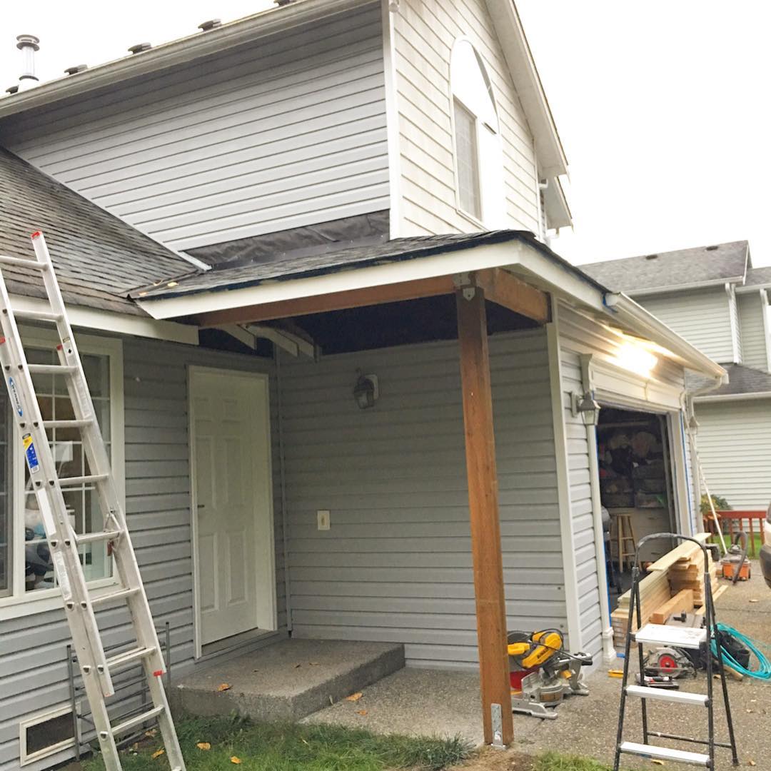 A home with a newly framed covered porch addition in progress