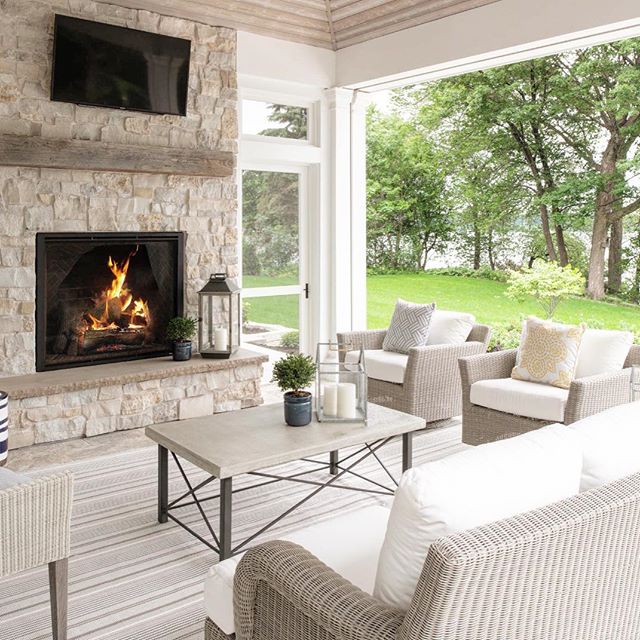 A finished living room with a floor-to-ceiling stone fireplace opening to the garden