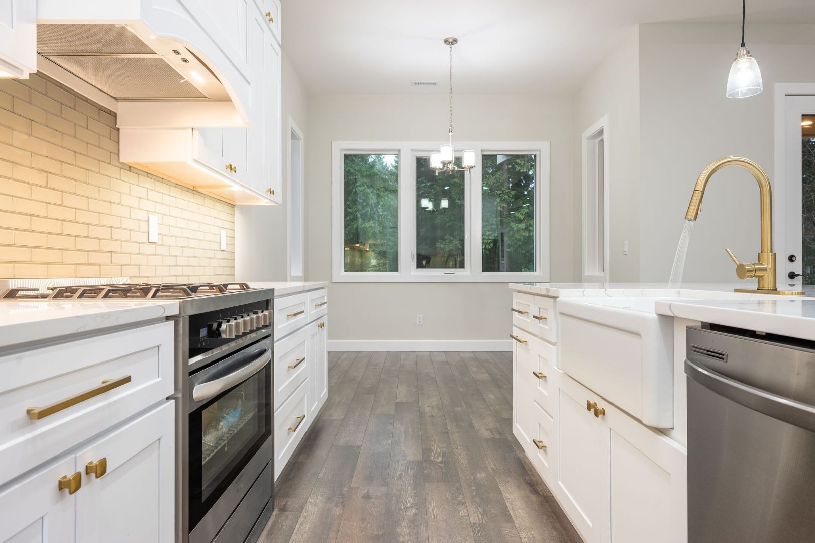 A bright remodeled kitchen with white cabinetry, subway tile and a farmhouse sink